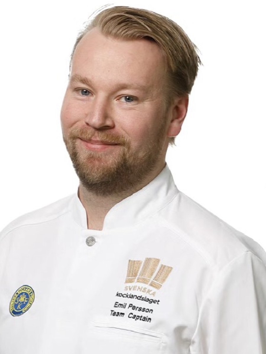 Emil Persson i kockrock med Svenska Kocklandslagets emblem